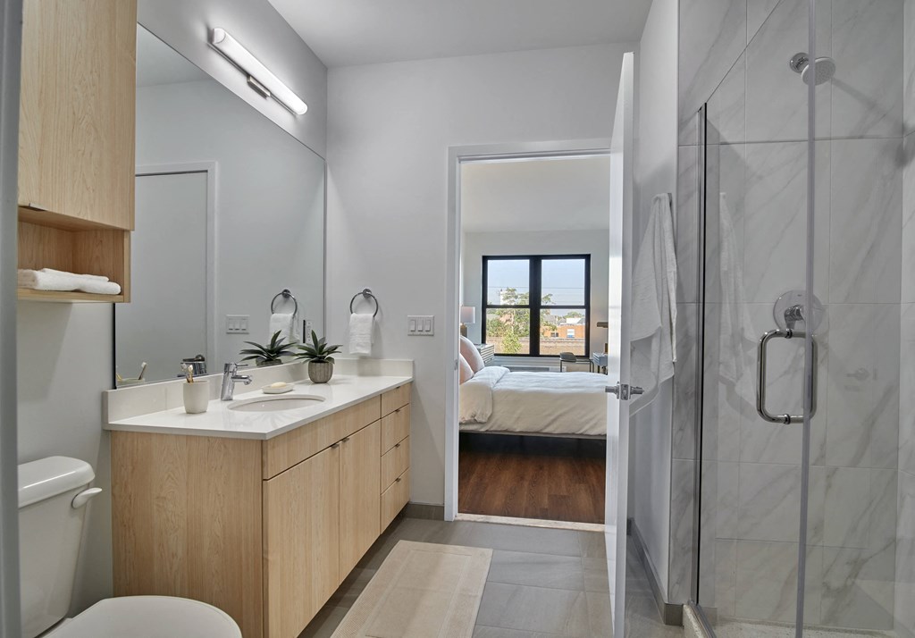 a bathroom with a shower and a sink and a bed