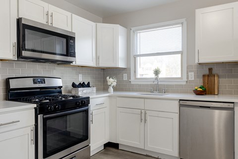 a kitchen with stainless steel appliances and white cabinets