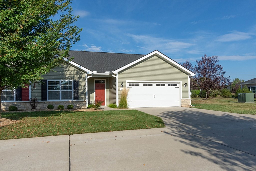 A house with a grey roof and a red door.