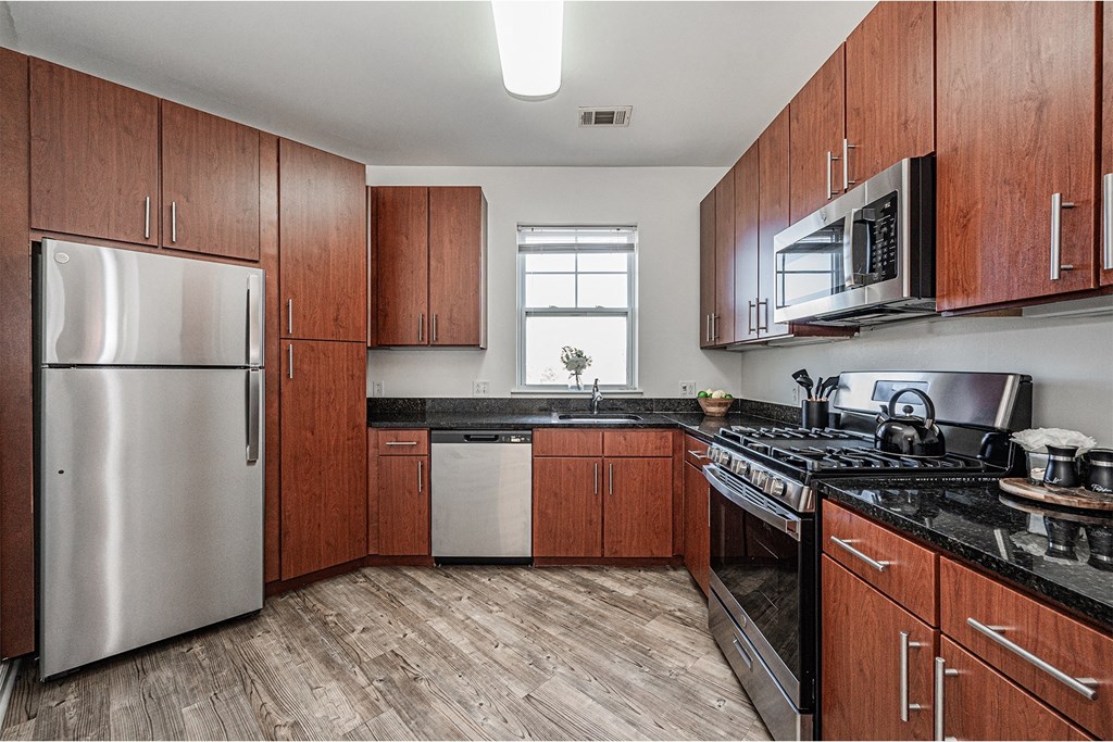 a kitchen with wooden cabinets and stainless steel appliances