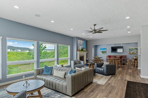 A living room with a grey couch and a ceiling fan.
