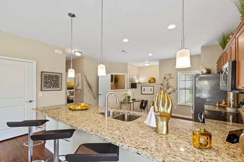 A kitchen with granite countertops and a bar area in a ranch-style home for rent in a private Florence, KY community