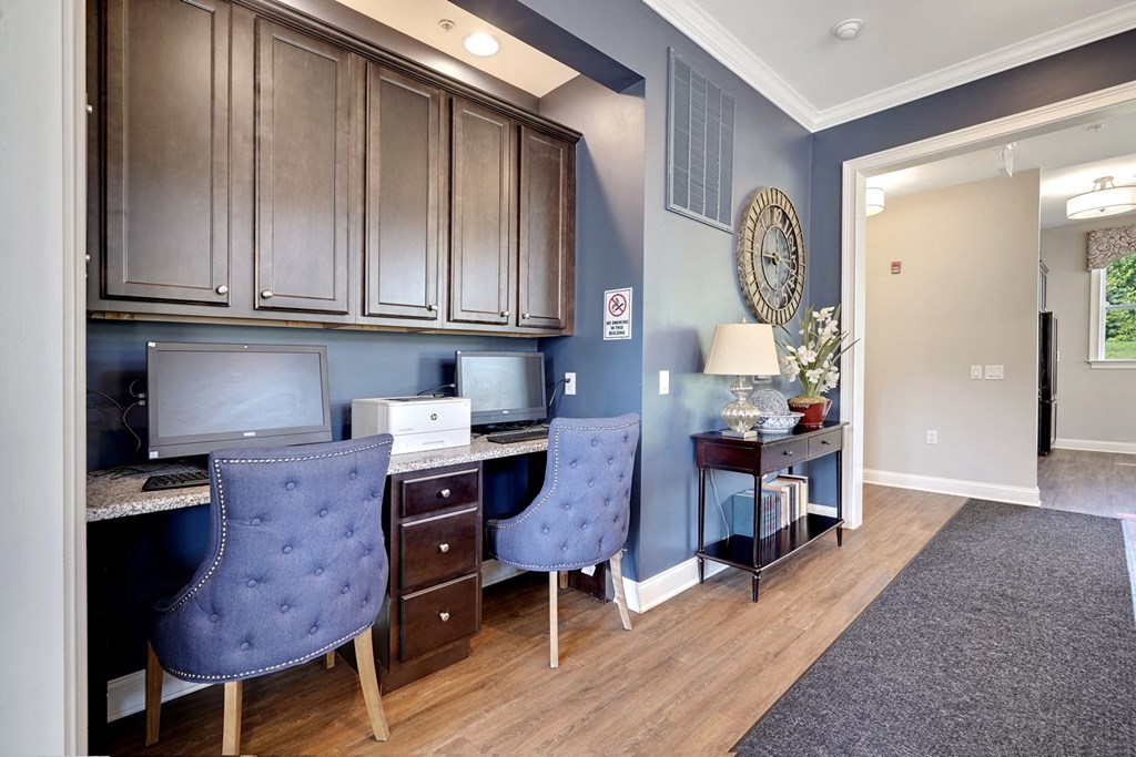 a home office with two chairs and a desk with a computer