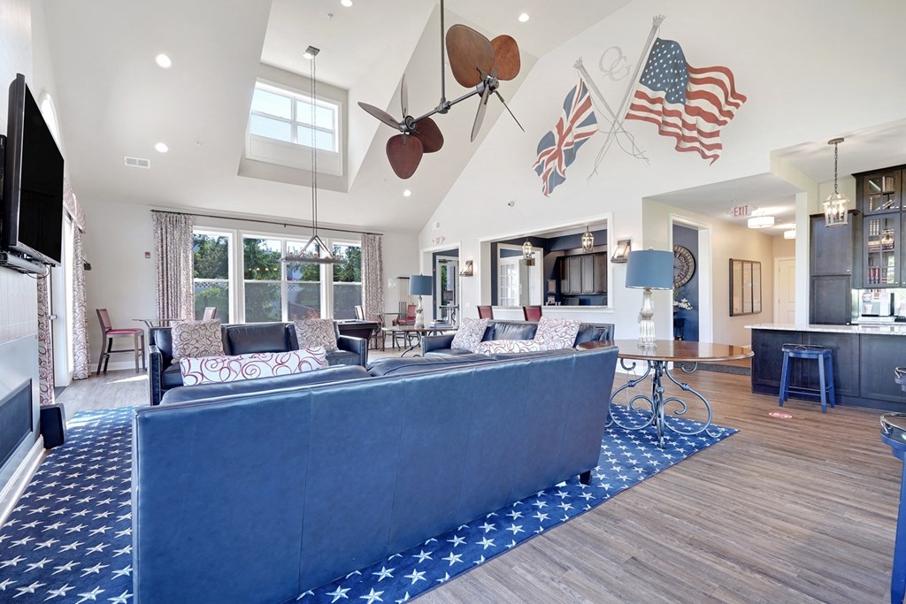 A living room with a blue carpet and a television.