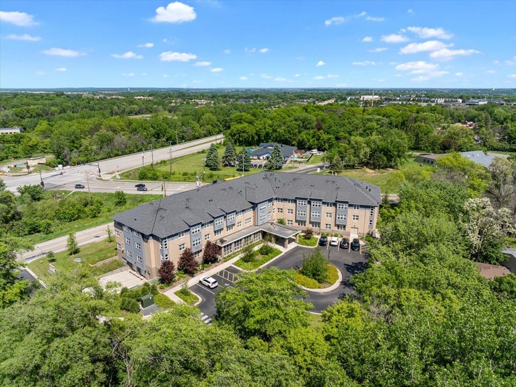 A large building surrounded by trees and a parking lot.