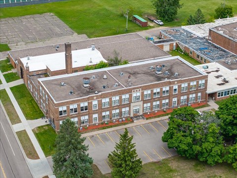 A large brick building with a parking lot in front.