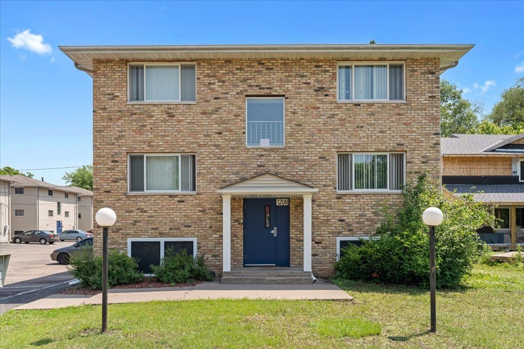 A brick house with a blue door and windows.