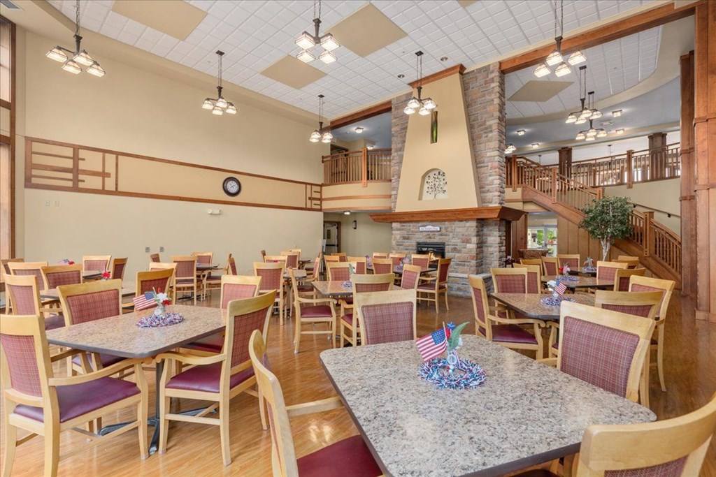 A dining room with tables and chairs and a clock on the wall.
