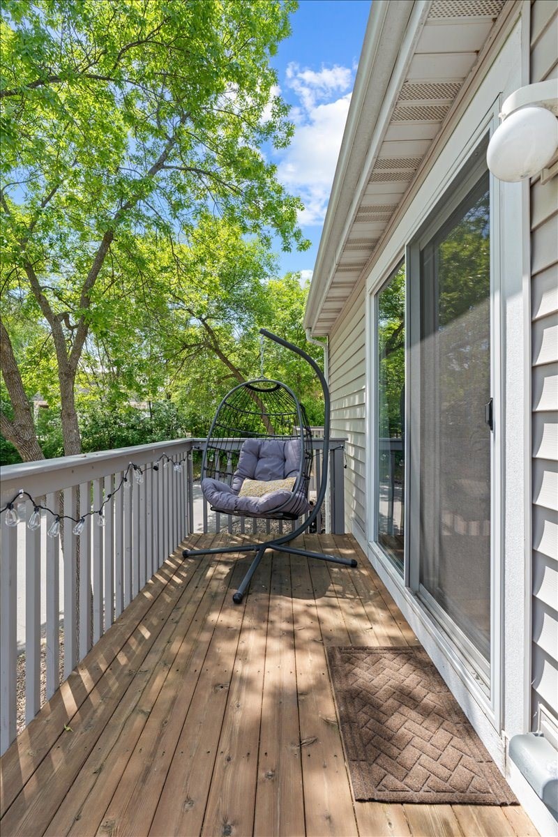 A wooden deck with a chair and table.