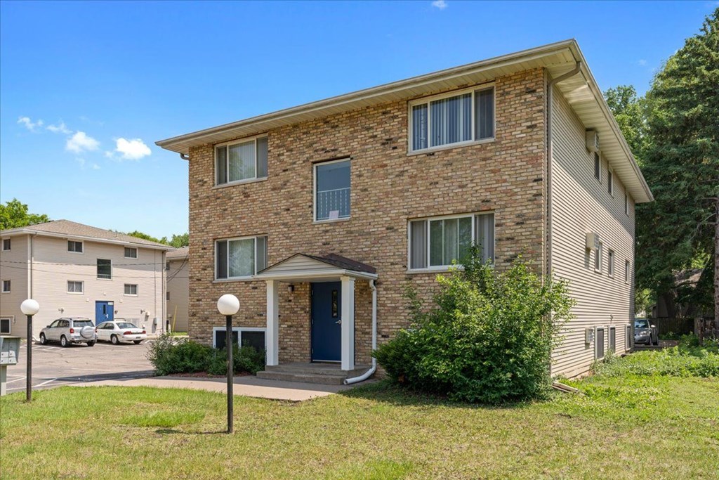 A brick house with a blue door and windows.