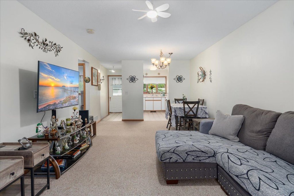 A living room with a grey couch and a television on the wall.