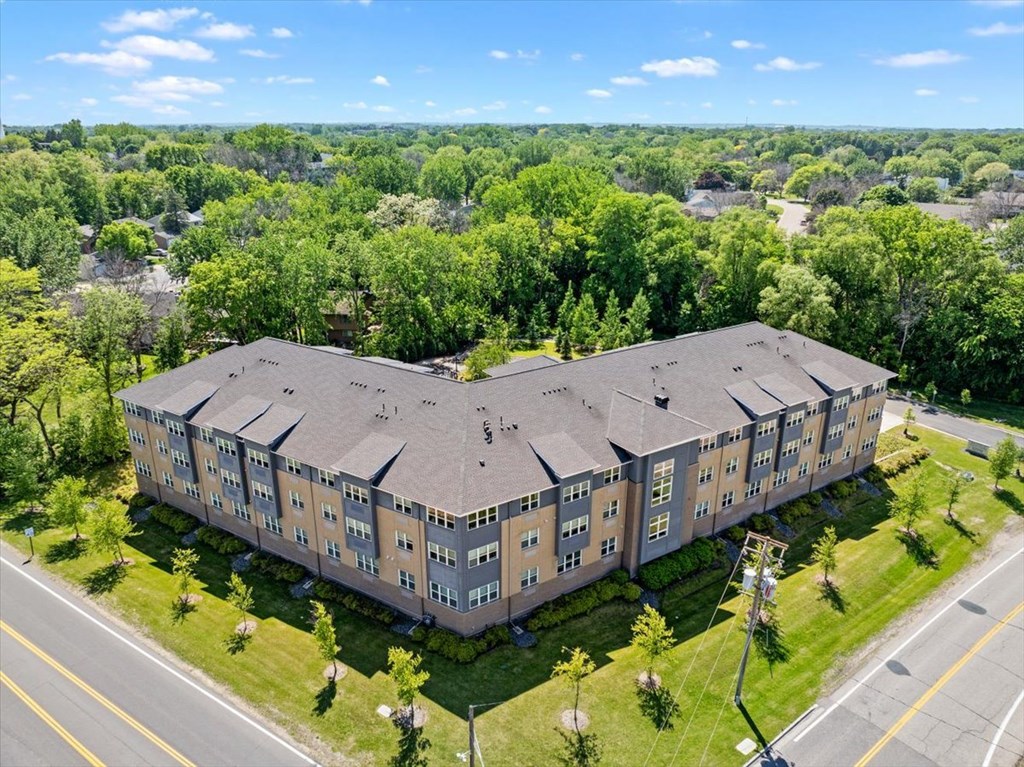 A large apartment complex with a green lawn in front.