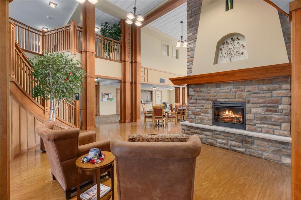 A living room with a fireplace and a staircase.
