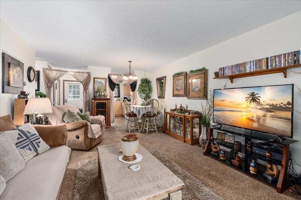 A living room with a large flat screen TV on the right side.