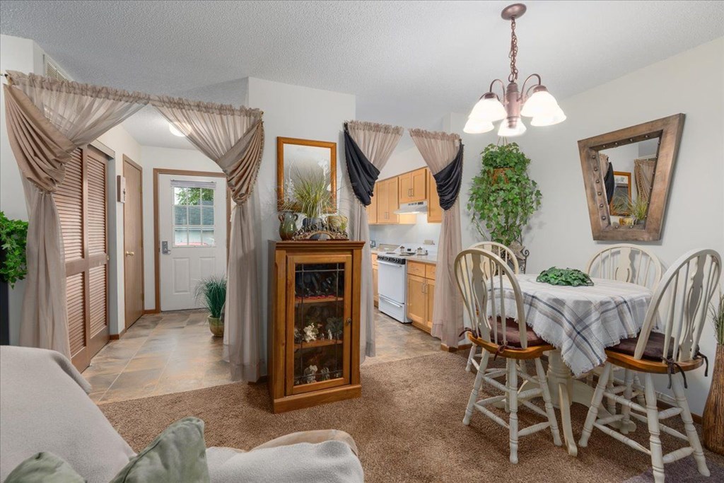 A dining room with a table set for four.
