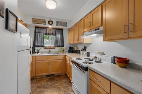 A kitchen with wooden cabinets and a white refrigerator.