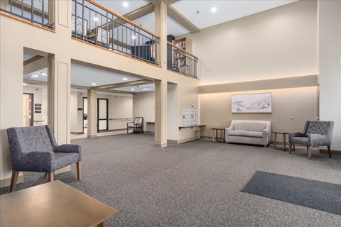 A spacious waiting room with a couch, chairs, and a coffee table.