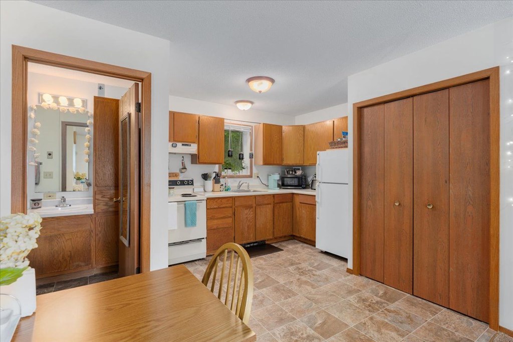 A kitchen with wooden cabinets and a tiled floor.
