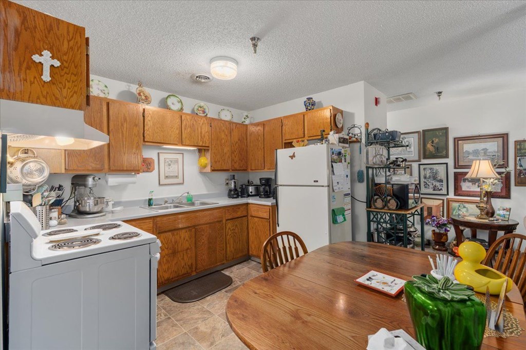 A kitchen with wooden cabinets and a white refrigerator.