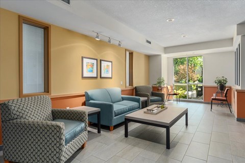A living room with a sofa, armchairs, and a coffee table.