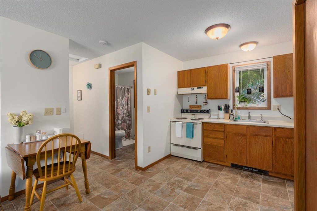 A kitchen with wooden cabinets and a tile floor.