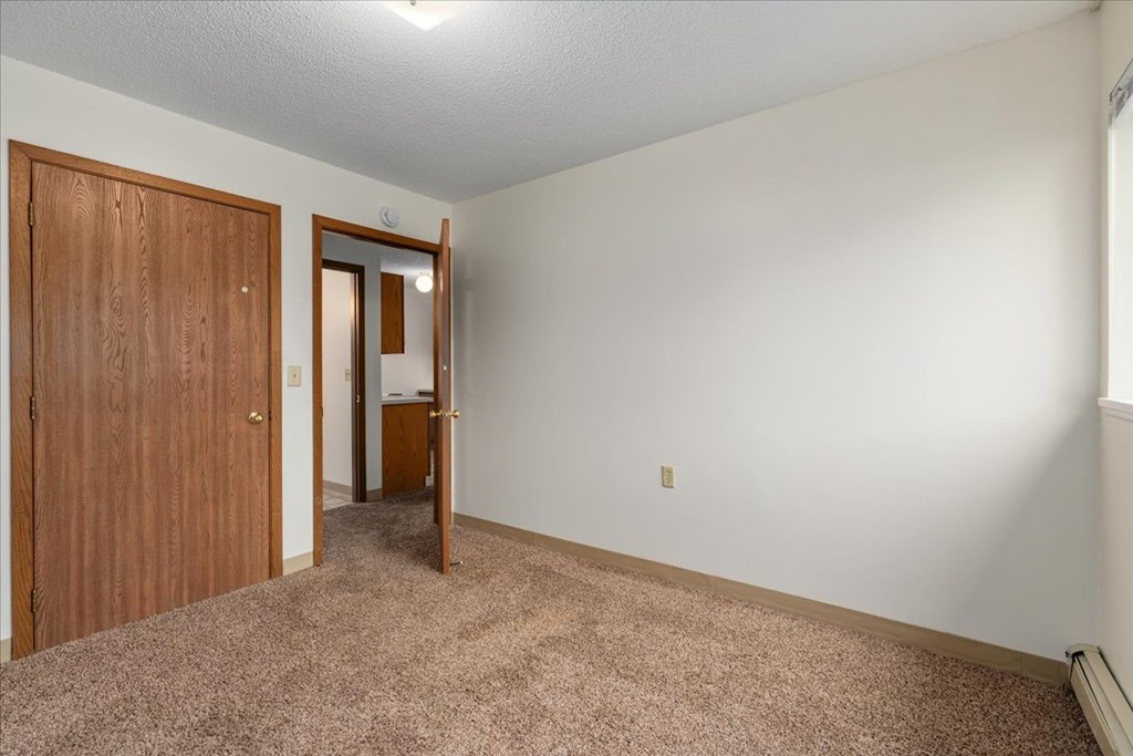 A room with a brown door and a white wall.