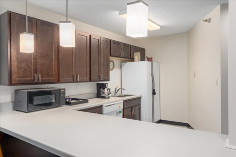 A kitchen with brown cabinets and a white counter.
