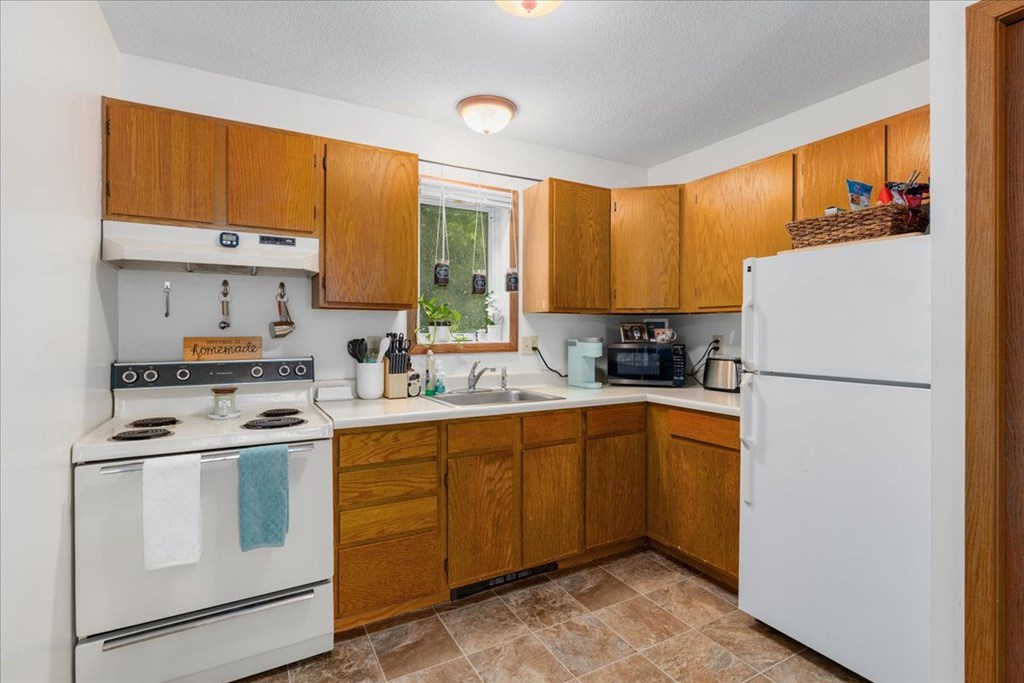 A kitchen with wooden cabinets and a white refrigerator.