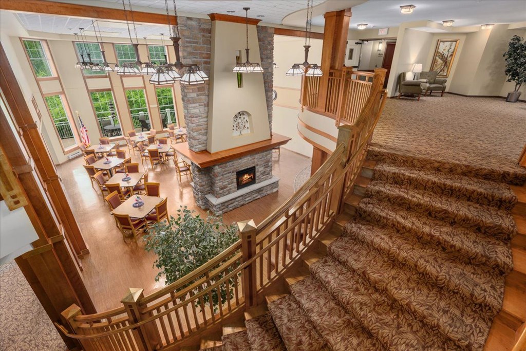 A large, well-lit living room with a staircase leading to the upper floor.