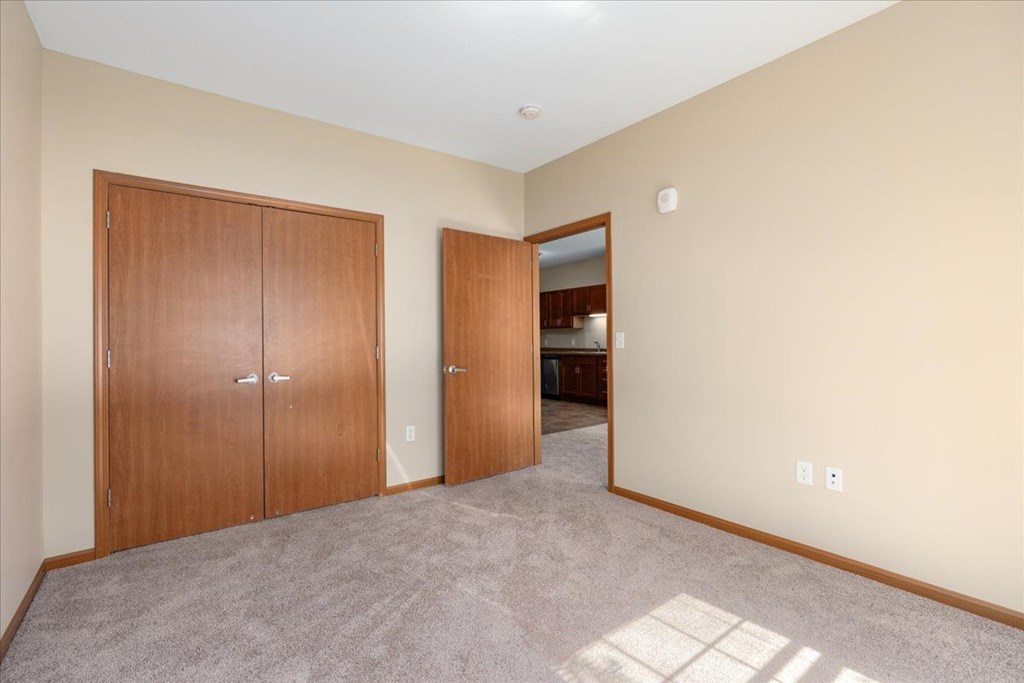 A room with two doors and a carpeted floor.