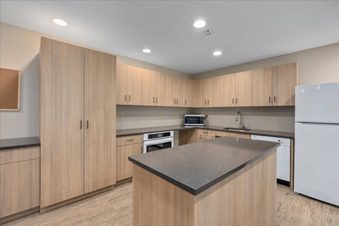 A kitchen with wooden cabinets and a black countertop.