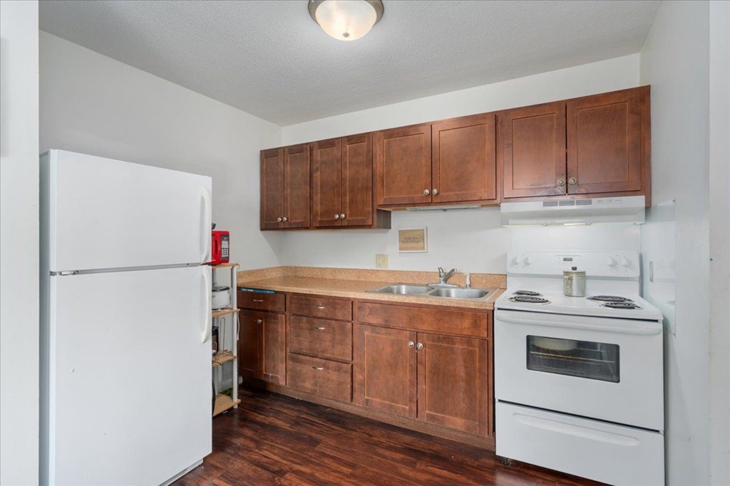 A kitchen with wooden cabinets and white appliances.
