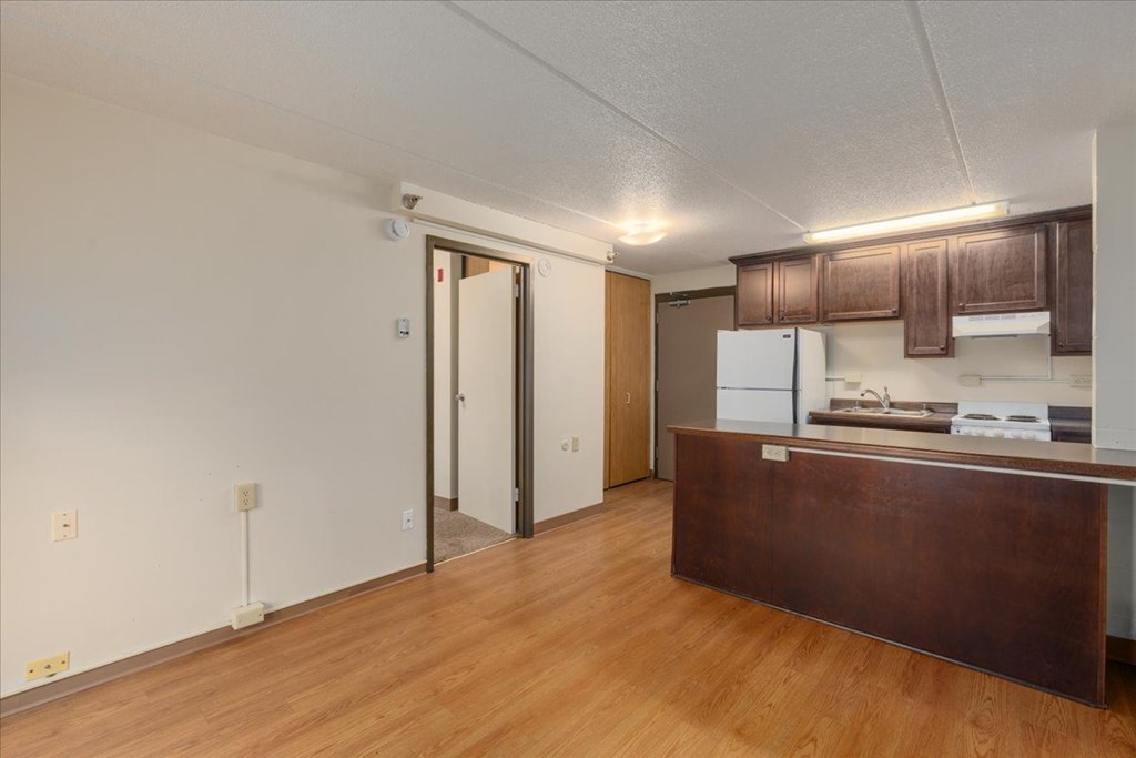 A kitchen with a brown counter and a white fridge.