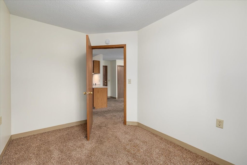 A room with a carpeted floor and a mirror on the wall.