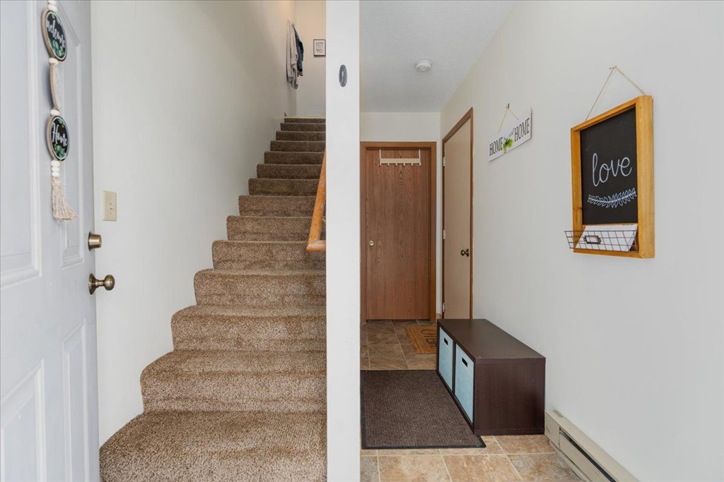 A hallway with a staircase and a chalkboard with the word "love" written on it.