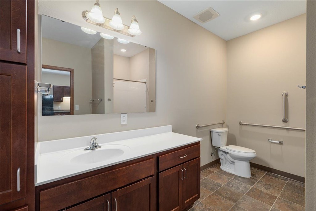 A bathroom with a white sink and a white toilet.