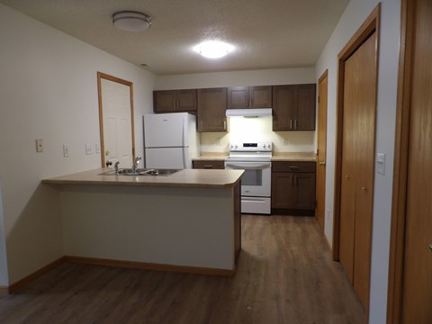 A kitchen with wooden floors and white appliances.