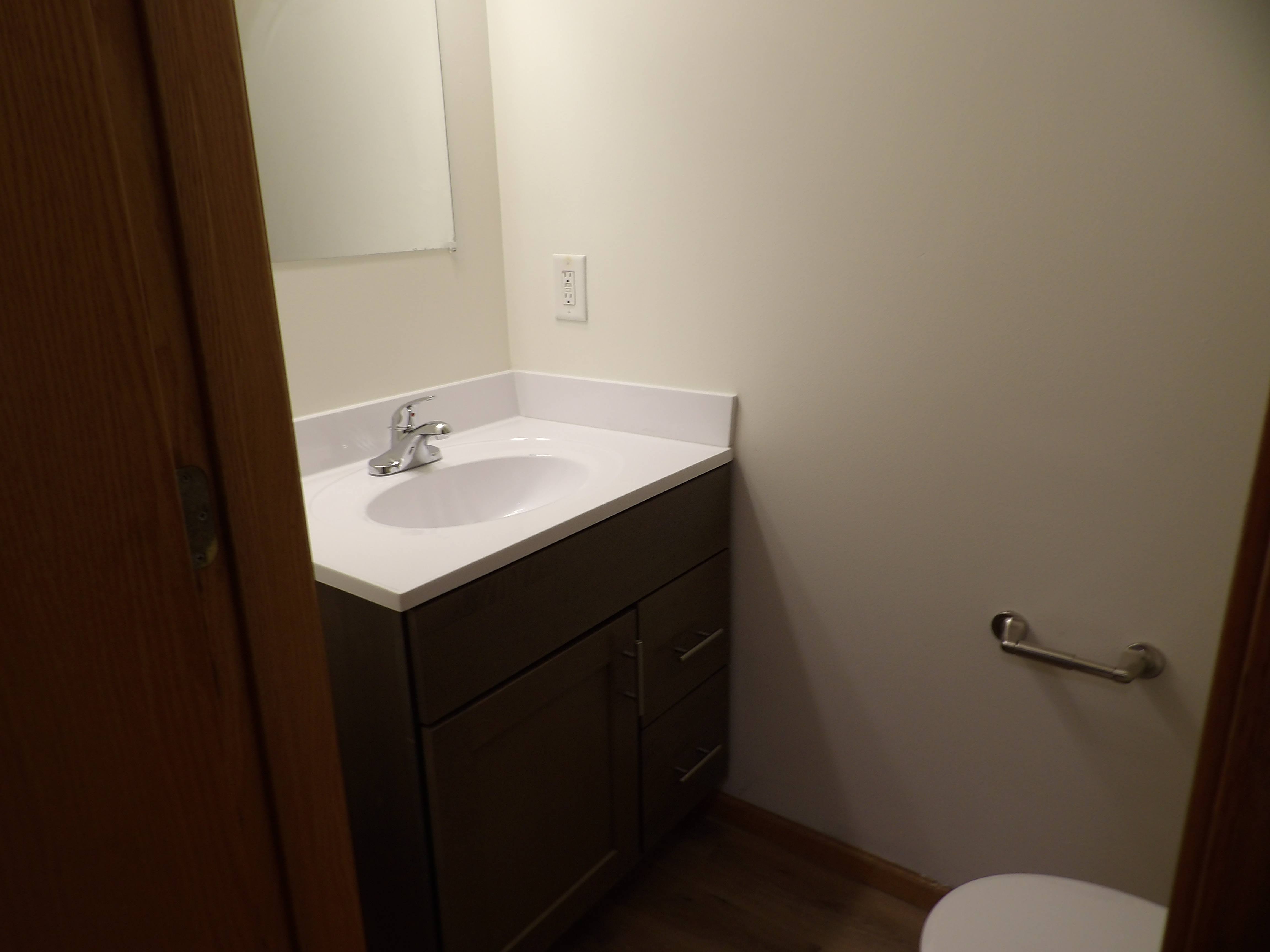 A bathroom with a white sink and a toilet.