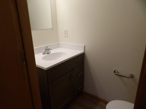 A bathroom with a white sink and a toilet.