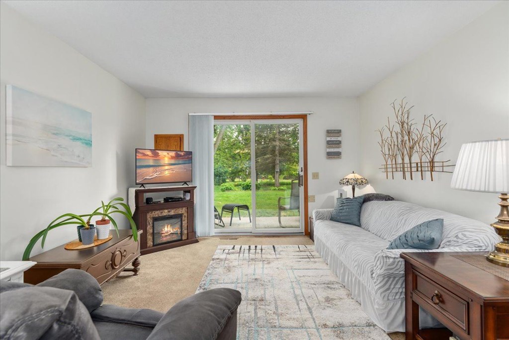 A cozy bedroom with a fireplace and a view of the backyard.
