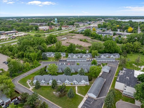 A bird's eye view of a residential area with houses and a parking lot.