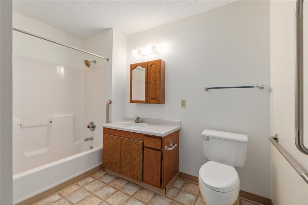 A white toilet sits next to a sink in a small bathroom.