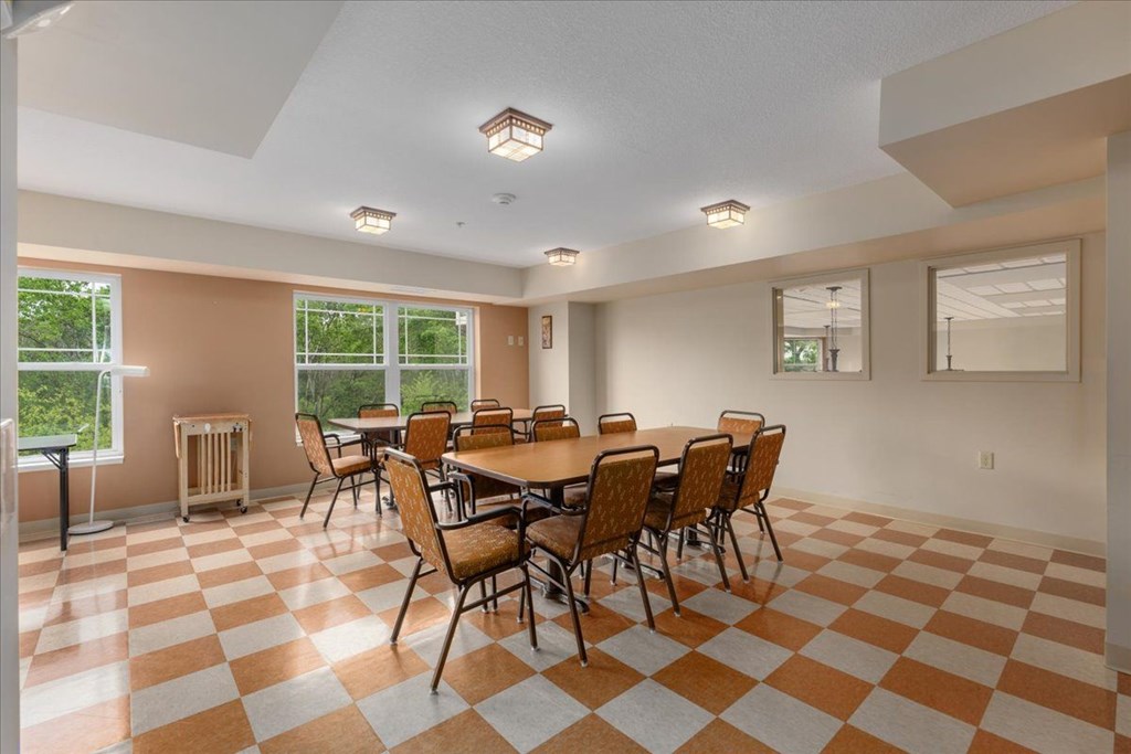 A room with a checkered floor and a table with chairs.