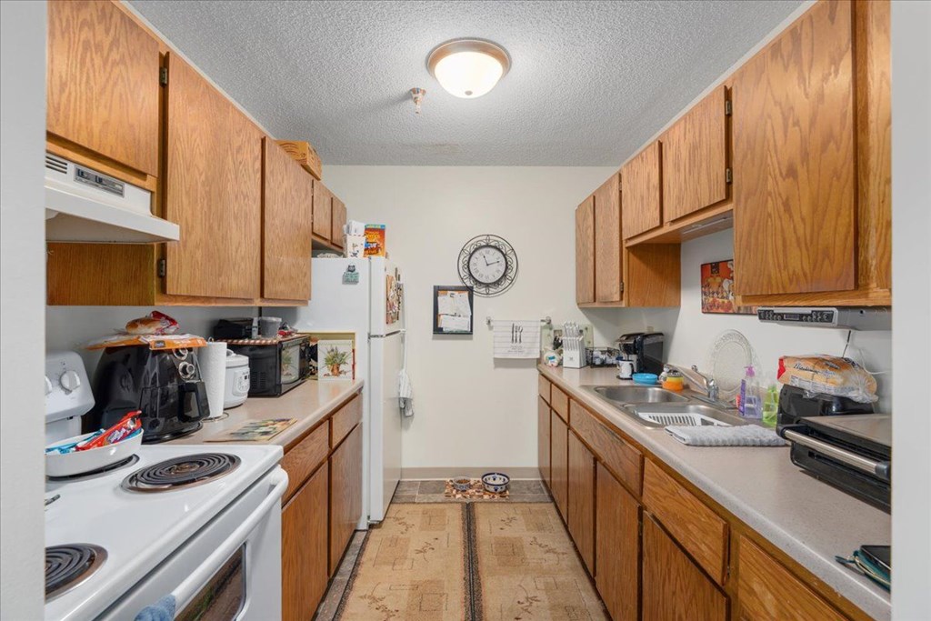 A kitchen with wooden cabinets and a white stove top.