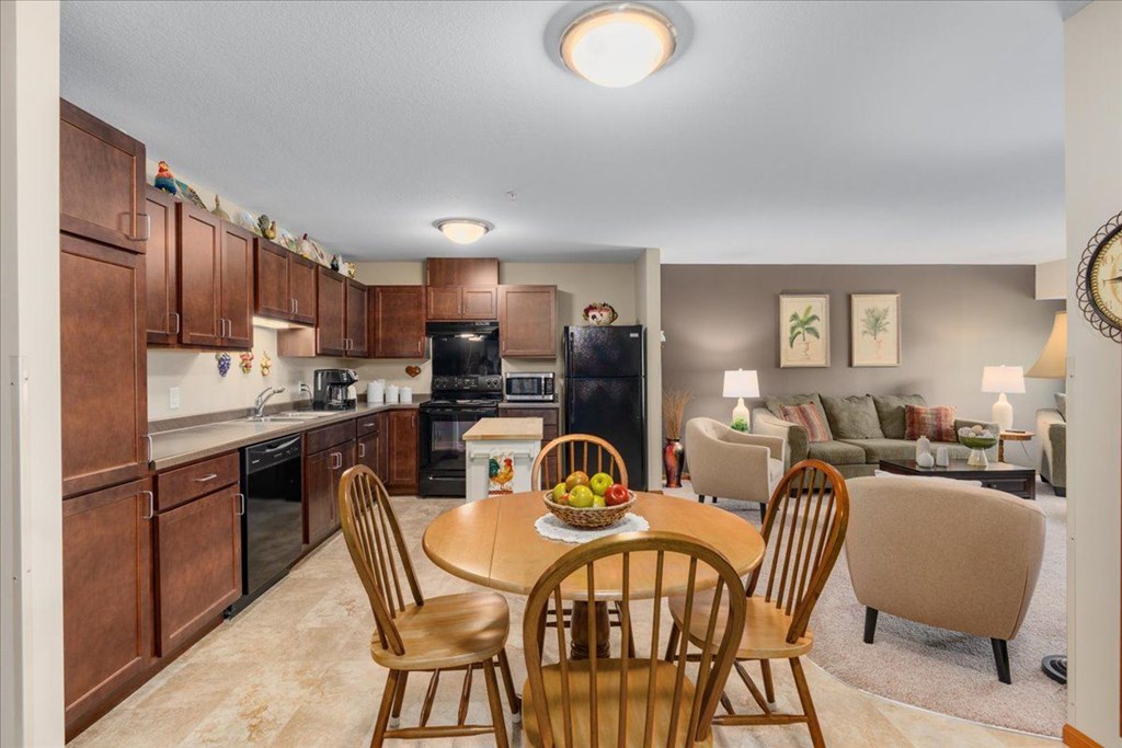 A kitchen with a table and chairs in the foreground.