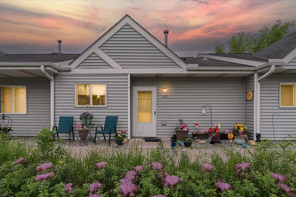 A house with a front porch and a garden in front.
