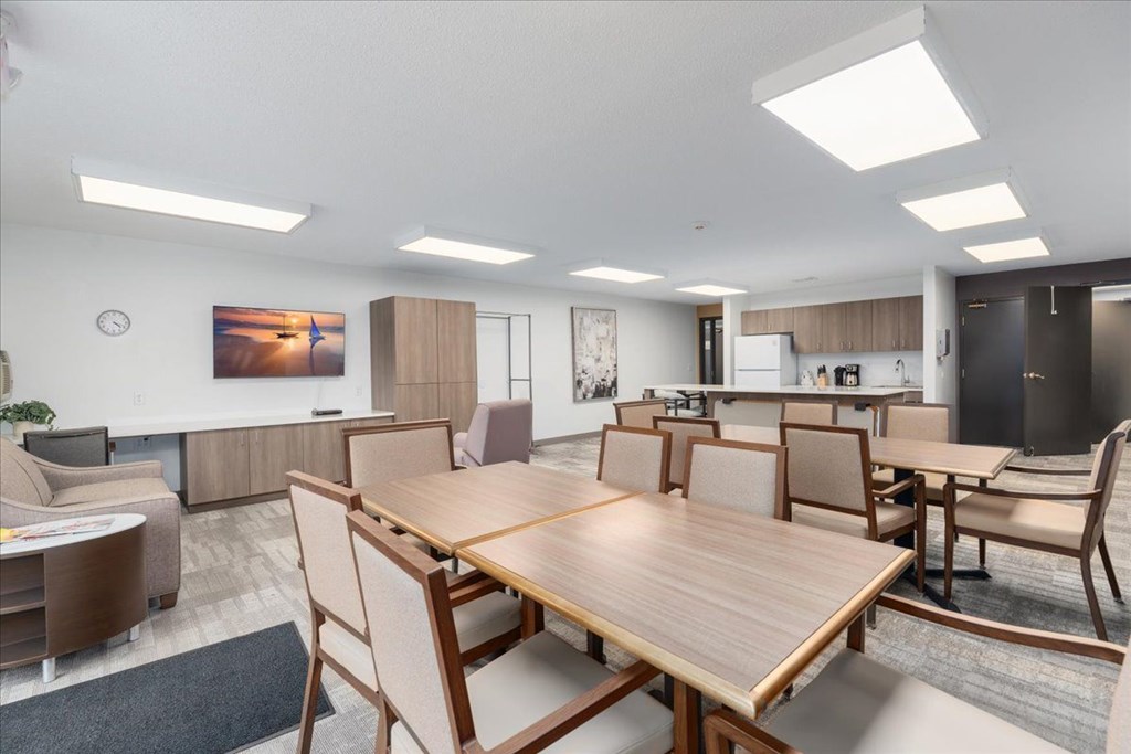 A modern dining room with a large wooden table and chairs.