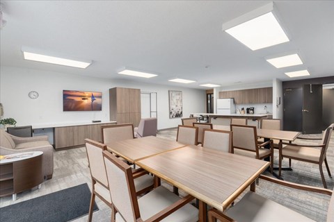 A modern dining room with a large wooden table and chairs.