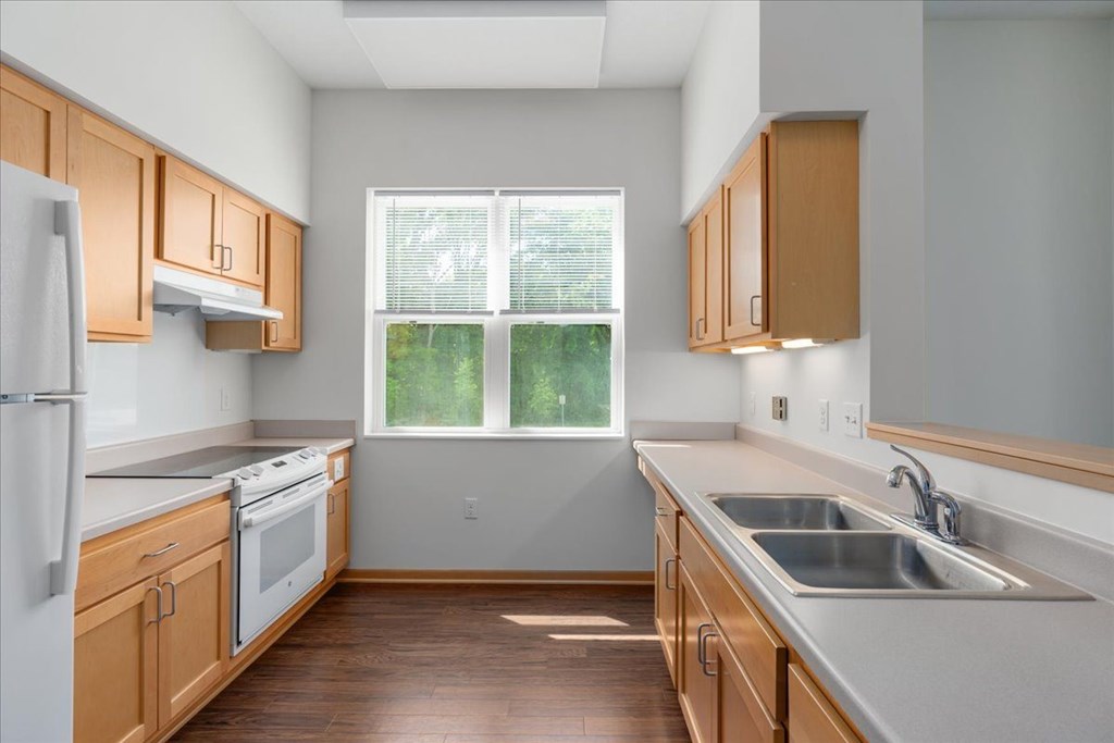 A kitchen with wooden cabinets and a white fridge.