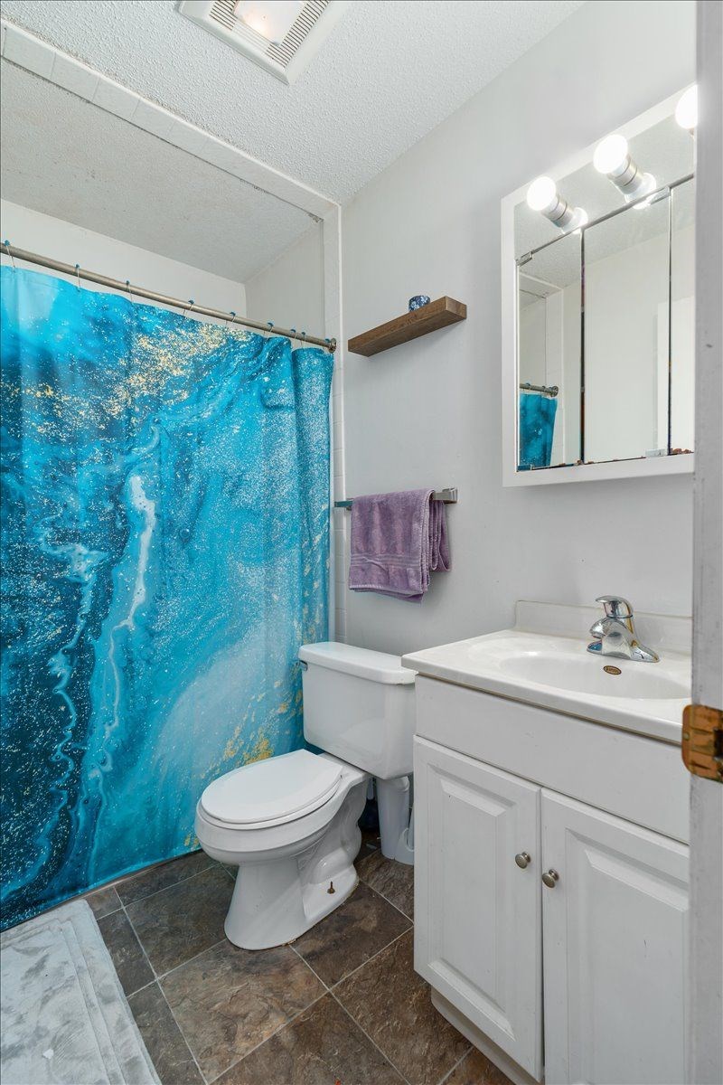 A white toilet sits next to a sink in a bathroom.